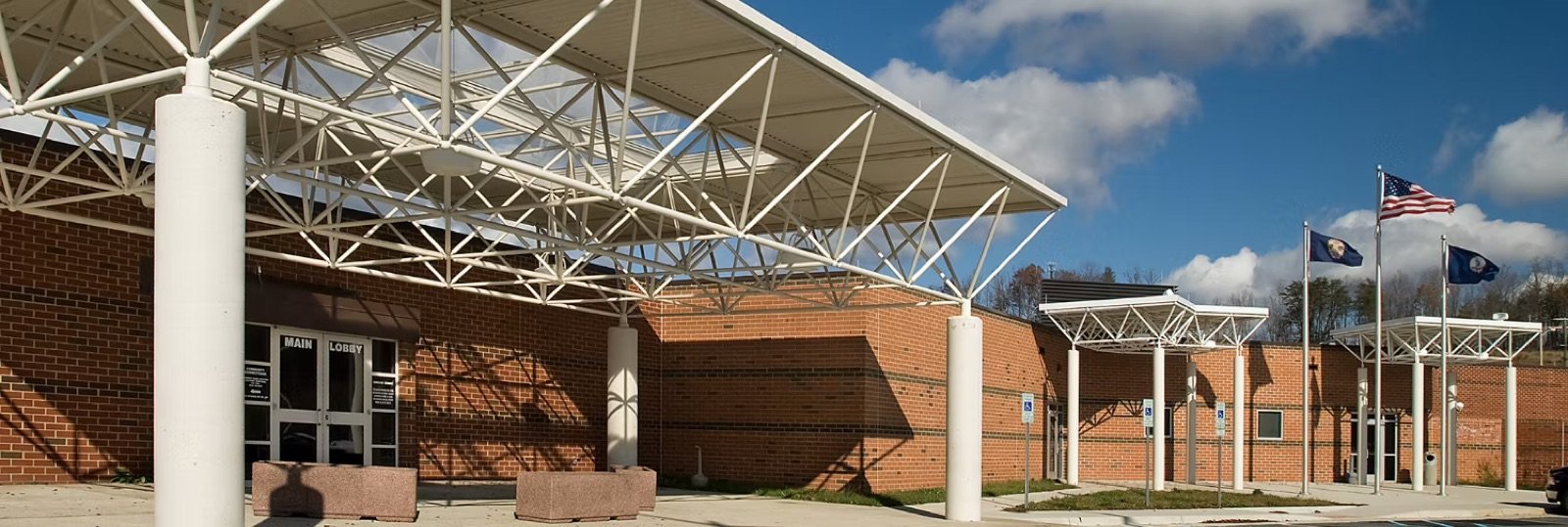The front of Rappahannock Regional Jail in Stafford, Virginia: a long low brick building under a wide sky.